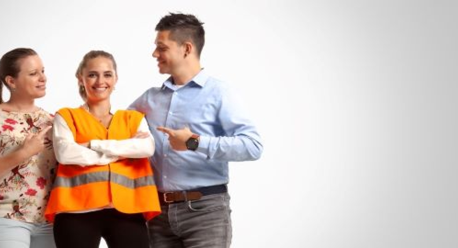 Afbeelding van een bedrijfshulpverlener in een oranje veiligheidshesje tussen haar collega's in.